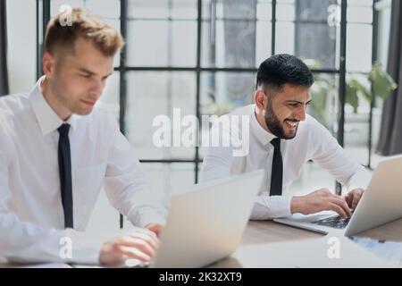 Deux hommes heureux travaillant ensemble sur un nouveau projet d'entreprise Banque D'Images