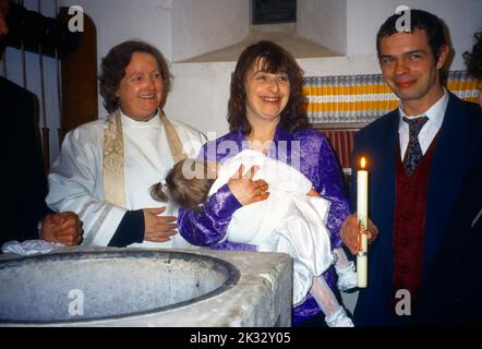 Parents de baptême tenant sa fille et Paschal Candle Chaldon Church Surrey Femme ministre Banque D'Images