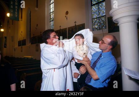 St Joseph's Church Roehampton Priest & parent Wrap White Cloth Round Baby Banque D'Images