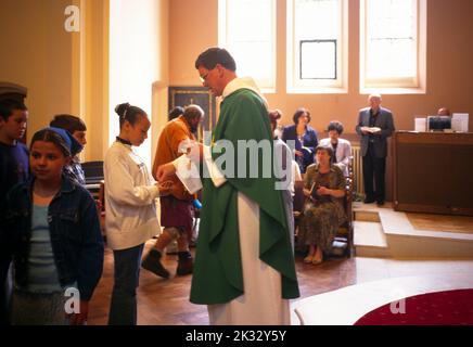 Gens en file d'attente pour la communion à l'église St Joseph Roehampton, Londres, Angleterre Banque D'Images