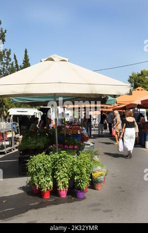 Personnes Shopping au samedi marché porte-affiche vendre le basilic et le chrysanthème Vouliagmeni Athènes Grèce Banque D'Images