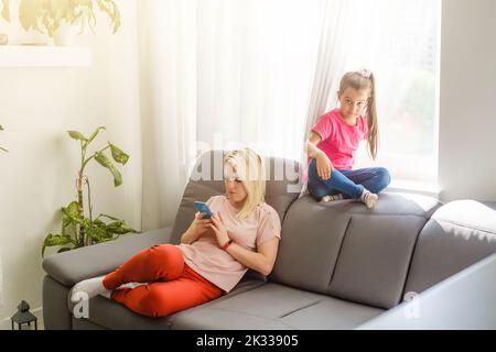 la mère joue au téléphone mais ne joue pas avec sa fille Banque D'Images