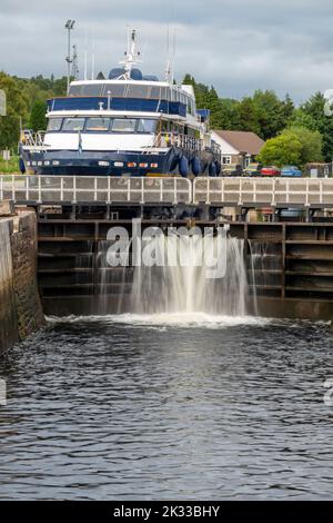 Début du canal calédonien, près de fort William et Ben Nevis, eau qui coule à travers les portes d'écluse, avec petit navire écossais derrière les portes, attendant Banque D'Images