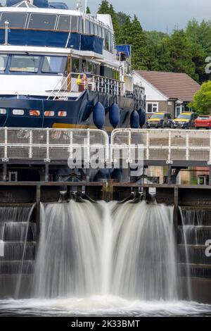 Début du canal calédonien, près de fort William et Ben Nevis, eau qui coule à travers les portes d'écluse, avec petit navire écossais derrière les portes, attendant Banque D'Images