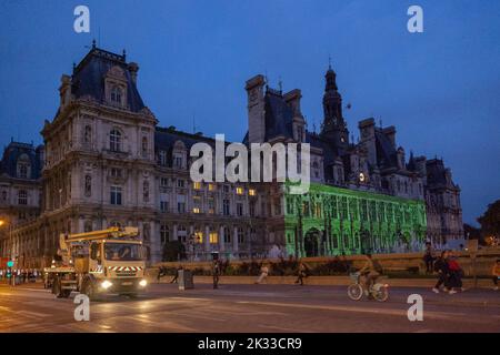 L'Hôtel de ville de Paris et la rue de Rivoli, avec un camion, à l'aube, avec des personnes marchant et un spectacle laser est projeté sur la façade de l'Hôtel de ville Banque D'Images