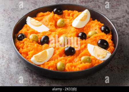 Apéritif de purée de carottes servi avec des œufs durs et des olives dans une assiette sur la table. Horizontal Banque D'Images