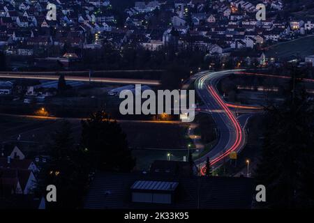 Route avec des sentiers légers à l'heure bleue avec paysage urbain Banque D'Images