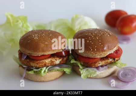 Hamburger au fromage maison. Paneer ou fromage cottage viandes, tomates, oignons et laitue placés dans des petits pains à hamburger faits maison. Prise de vue sur fond blanc Banque D'Images