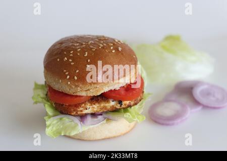 Hamburger au fromage maison. Paneer ou fromage cottage viandes, tomates, oignons et laitue placés dans des petits pains à hamburger faits maison. Prise de vue sur fond blanc Banque D'Images