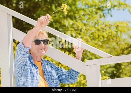 Mature femme attrayante voyageur assis seul sur la terrasse du café de plage Banque D'Images