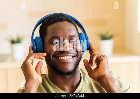 homme hispanique écoutant de la musique dans un casque sans fil à la maison Banque D'Images