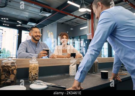 Trois employés de l'entreprise apprécient leur pause-café Banque D'Images
