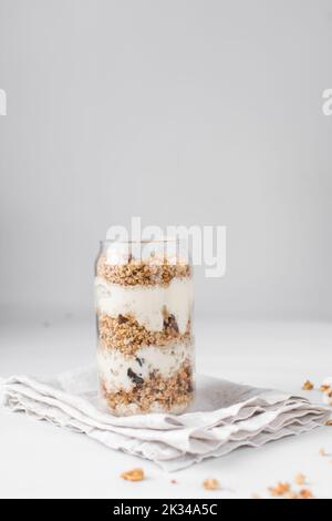 Pain de granola et de yaourt dans un verre en forme de pot, avoine et noix de parapain, pain de miel grillé avec des couches de yaourt dans une tasse en verre de pot Banque D'Images