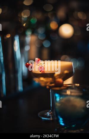 photo d'un cocktail présenté dans un bar à cocktails moody avec barman Banque D'Images