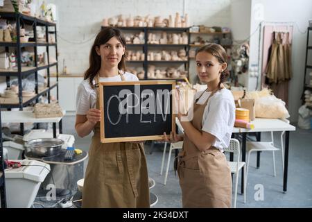 Les artistes féminins tiennent une plaque de bois sur la découverte entre leurs mains Banque D'Images