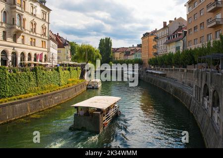Des bateaux touristiques passent le long de la rivière Ljubljana, dans le centre de Ljubljana, en Slovénie Banque D'Images