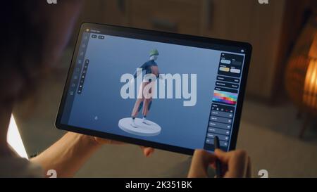 Homme 3D designer de création de vêtements dans l'application de modélisation 3D à l'aide d'un ordinateur tablette et d'un crayon numérique tout en travaillant à distance sur un projet indépendant Banque D'Images