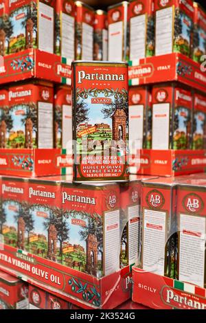 Boîtes d'huile d'olive extra vierge de Partanna empilées sur un marché. En cas de rosaces, plusieurs boîtes sont exposées. Faible profondeur de mise au point. Produit de l'Italie. Banque D'Images