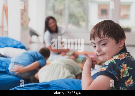 Un garçon avec le syndrome de Down passer du temps ensemble dans une institution préscolaire et jouer des jeux Banque D'Images