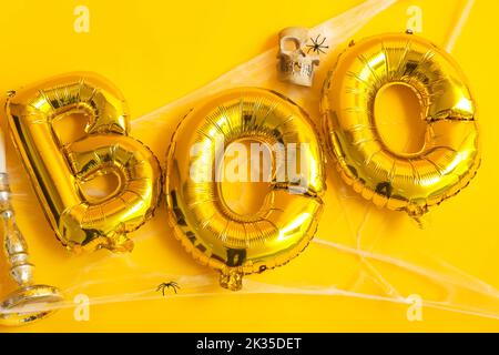 Mot BOO fait de ballons avec décor d'Halloween sur fond jaune Banque D'Images