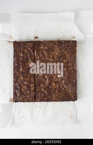 Couche plate de brownies, brownies qui ont été coupés en carrés, brownies caramel sur papier parchemin blanc Banque D'Images