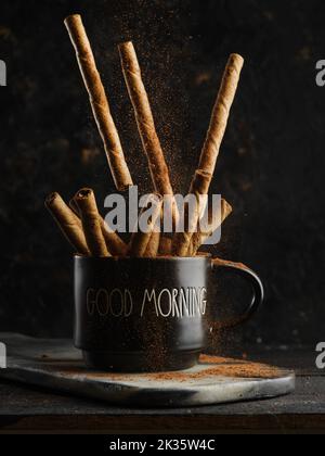 Beaucoup de bâtons de cannelle parfumés dans une tasse sur fond noir. Additif aromatique, épices pour café, thé, cocktail, boissons alcoolisées. Symbole de TH Banque D'Images