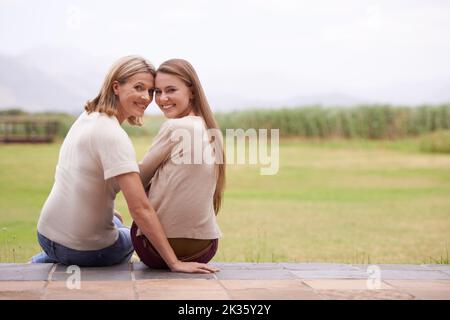 Passer du temps de qualité ensemble. Une mère et une fille assises à l'extérieur. Banque D'Images