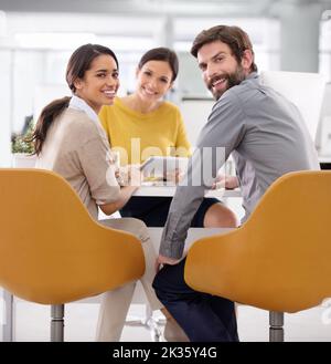 Ensemble, tous les meilleurs résultats sont obtenus : un groupe souriant de gens d'affaires assis autour d'une table. Banque D'Images