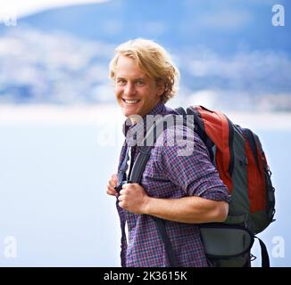 Allons commencer cette randonnée. Portrait d'un beau jeune homme avec un sac à dos dans la nature. Banque D'Images