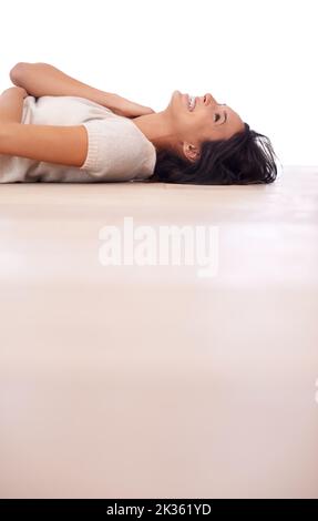 Un peu de frisseux par terre. Vue en contre-angle d'une belle jeune femme qui s'est allongée sur le dos, sur un parquet. Banque D'Images