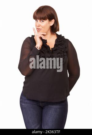 C'est juste entre vous et moi. Portrait d'une jolie brunette avec son doigt devant ses lèvres. Banque D'Images