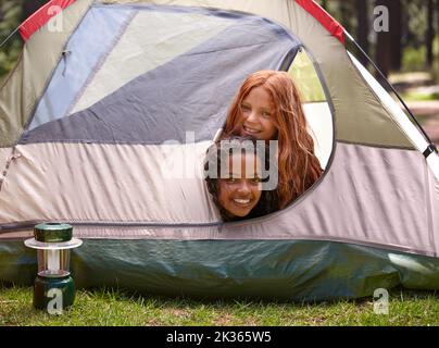 Les garçons ne sont pas admis. Deux jeunes filles partagent une tente pendant le camping. Banque D'Images