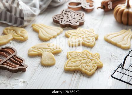 Cuisson de biscuits sous forme de citrouille et de feuilles. Pâtisserie d'automne confortable. Pâte avec emporte-pièces. Banque D'Images