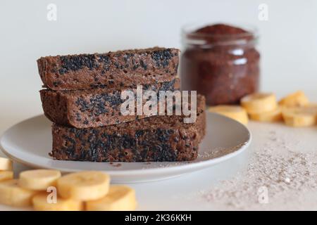 Gâteau Ragi plantain. Gâteau au thé sans gluten composé de farine de millet et de plantain mûr en purée, parsemé de graines de sésame noir. Prise de vue en blanc Banque D'Images