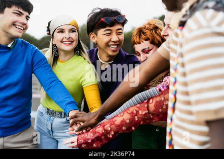 Joyeux jeunes amis divers ayant plaisir à empiler les mains ensemble en plein air - jeunes gens concept de génération millénaire Banque D'Images