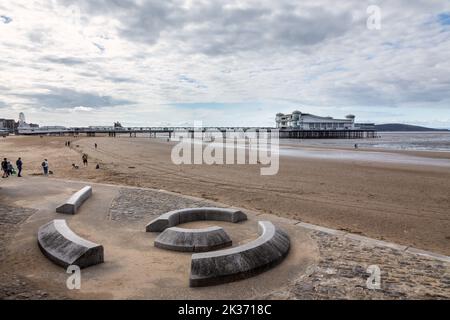 Décor de sièges en granit sur la plage de Weston Super Mare avec le Grand Pier en arrière-plan, Weston Super Mare, North Somerset, Angleterre, Royaume-Uni Banque D'Images