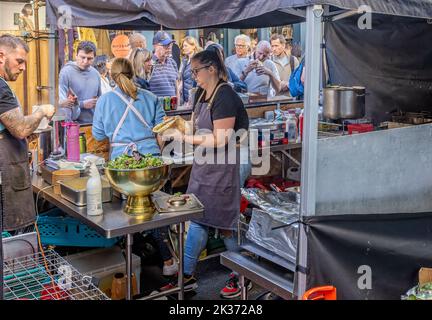Cuisiniers préparant et servant la nourriture d'un stand au festival de la nourriture de rue Great Bath Feast à Milsom Street, Bath, Avon, Royaume-Uni, le 24 septembre 2022 Banque D'Images