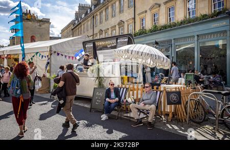 Les personnes qui ont pris un verre se sont assis dans des chaises longues au festival de la cuisine de rue Great Bath Feast à Milsom Street, Bath, Avon, Royaume-Uni, le 24 septembre 2022 Banque D'Images