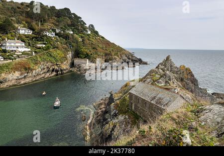 Perchée sur une falaise à l'embouchure de la rivière Pol The Net Loft au petit village de pêcheurs de Polperro, dans le sud des Cornouailles. South West Coast Path Banque D'Images