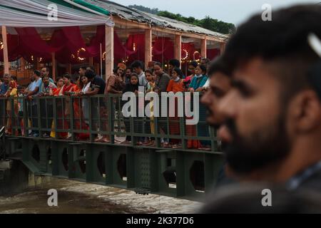 Rishikesh, Uttarakhand, Inde. 23rd septembre 2022. Les dévotés se tiennent sur un pont au-dessus du Gange en attendant la soirée Aarti, interprétée par le chef spirituel et les disciples de Parmarth Niketan Ashram. Parmarth Niketan fondé en 1942 par Pujya Swami Sukhdevanandji Maharaj est le plus grand Ashram de Rishikesh, avec plus de 1000 chambres fournissant une atmosphère propre, pure et sacrée avec des jardins abondants et magnifiques à des milliers de pèlerins qui viennent de tous les coins de la Terre. Les activités quotidiennes du Parmarth Niketan comprennent le yoga quotidien spécialisé dans le Vinyasa Yoga, le yoga général Hatha et le yoga Nindr Banque D'Images