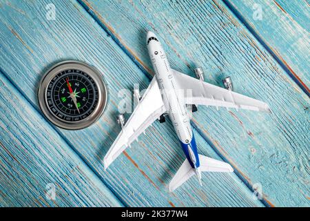 Modèle d'avion de tourisme avec boussole, isolé sur fond blanc. Concept de voyage. Flat lay, vue de dessus Banque D'Images