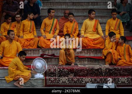 Rishikesh, Uttarakhand, Inde. 23rd septembre 2022. Les jeunes rishikumurs de Parmarth Niketan Ashram s'assoient sur les escaliers du ghat avant de faire leur soirée quotidienne Aarti à la rivière Ganges. Parmarth Niketan fondé en 1942 par Pujya Swami Sukhdevanandji Maharaj est le plus grand Ashram de Rishikesh, avec plus de 1000 chambres fournissant une atmosphère propre, pure et sacrée avec des jardins abondants et magnifiques à des milliers de pèlerins qui viennent de tous les coins de la Terre. Les activités quotidiennes du Parmarth Niketan comprennent le yoga quotidien spécialisé dans le Vinyasa Yoga, le yoga général Hatha, et le yoga Nindra, Morning U. Banque D'Images