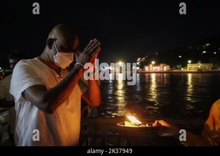 23 septembre 2022, Rishikesh, Uttarakhand, Inde: Un dévot prend des bénédictions de la flamme d'Aarti après la soirée quotidienne d'Aarti au Gange. .Parmarth Niketan fondé en 1942 par Pujya Swami Sukhdevanandji Maharaj est le plus grand Ashram de Rishikesh, avec plus de 1000 chambres fournissant une atmosphère propre, pure et sacrée avec des jardins abondants et magnifiques à des milliers de pèlerins qui viennent de tous les coins de la Terre. .Les activités quotidiennes au Parmarth Niketan incluent le yoga quotidien spécialisé dans le Vinyasa Yoga, le yoga général Hatha, et le yoga Nindra, les prières universelles du matin et les cours de méditation, tous les jours Banque D'Images