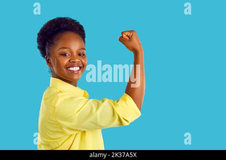 Portrait d'une jeune femme afro-américaine heureuse et forte qui se plie le bras et souriait Banque D'Images