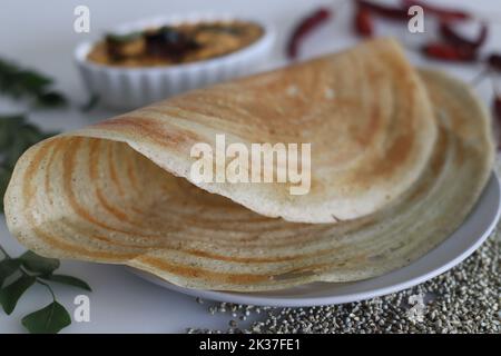 Rôti de ghee Bajra. Fines crêpes croustillantes faites avec une pâte fermentée de millet perlé et de lentilles ajoutant du ghee. Servi avec des condiments épicés à la noix de coco. Prise de vue Banque D'Images