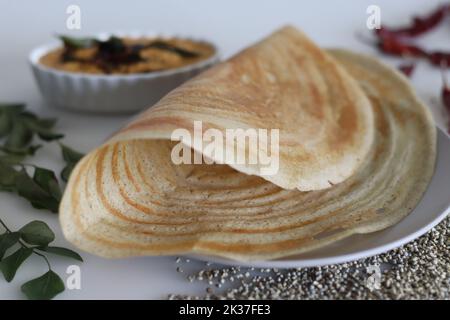 Rôti de ghee Bajra. Fines crêpes croustillantes faites avec une pâte fermentée de millet perlé et de lentilles ajoutant du ghee. Servi avec des condiments épicés à la noix de coco. Prise de vue Banque D'Images