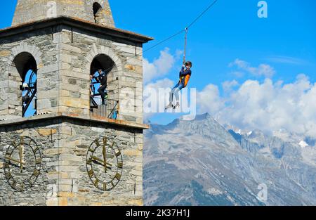 Garçon glissant sur une ligne de fermeture à glissière depuis la tour de l'église, Chinderwältfäscht, Festival mondial des enfants, Heidadorf Visperterminen, Valais, Suisse Banque D'Images