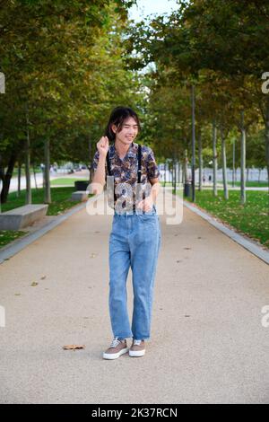Un gars taïwanais souriant et dansant rock and roll dans un parc. Banque D'Images