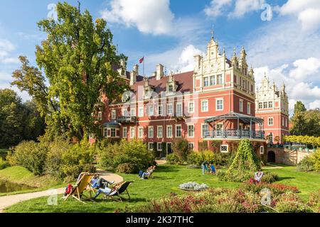 25 septembre 2022, Saxe, Bad Muskau: Dans le parc Fürst Pückler de Bad Muskau, les visiteurs s'assoient sur des chaises longues par beau temps devant le nouveau château. Photo: Frank Hammerschmidt/dpa Banque D'Images