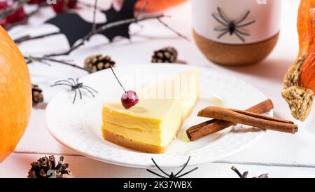 Tarte douce à la citrouille sur une assiette blanche avec décorations de fête traditionnelles araignées et hiboux noirs. Composition pour Halloween avec pâtisserie de saison des fêtes Banque D'Images